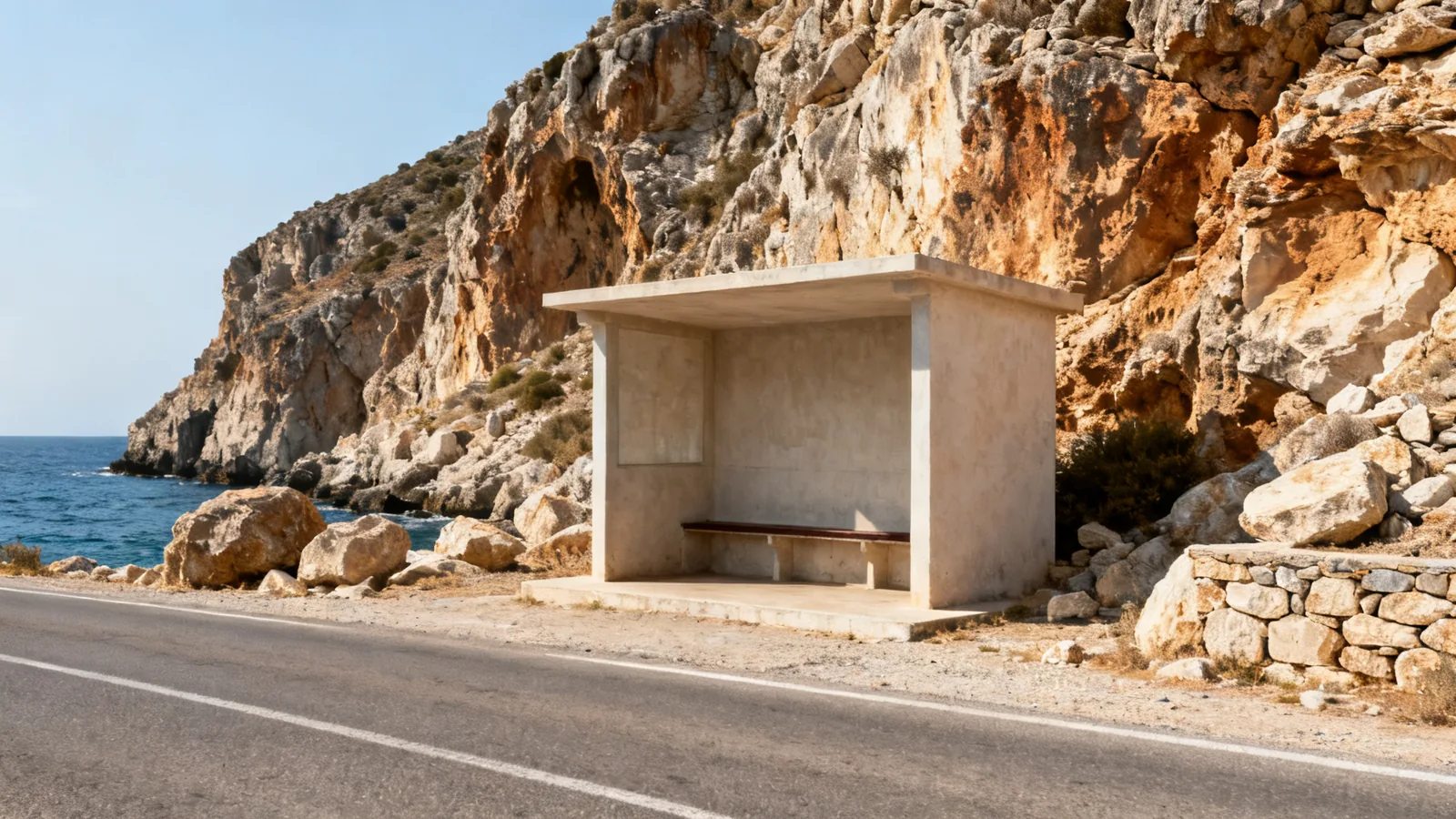 A quiet roadside passenger shelter by a rocky coast