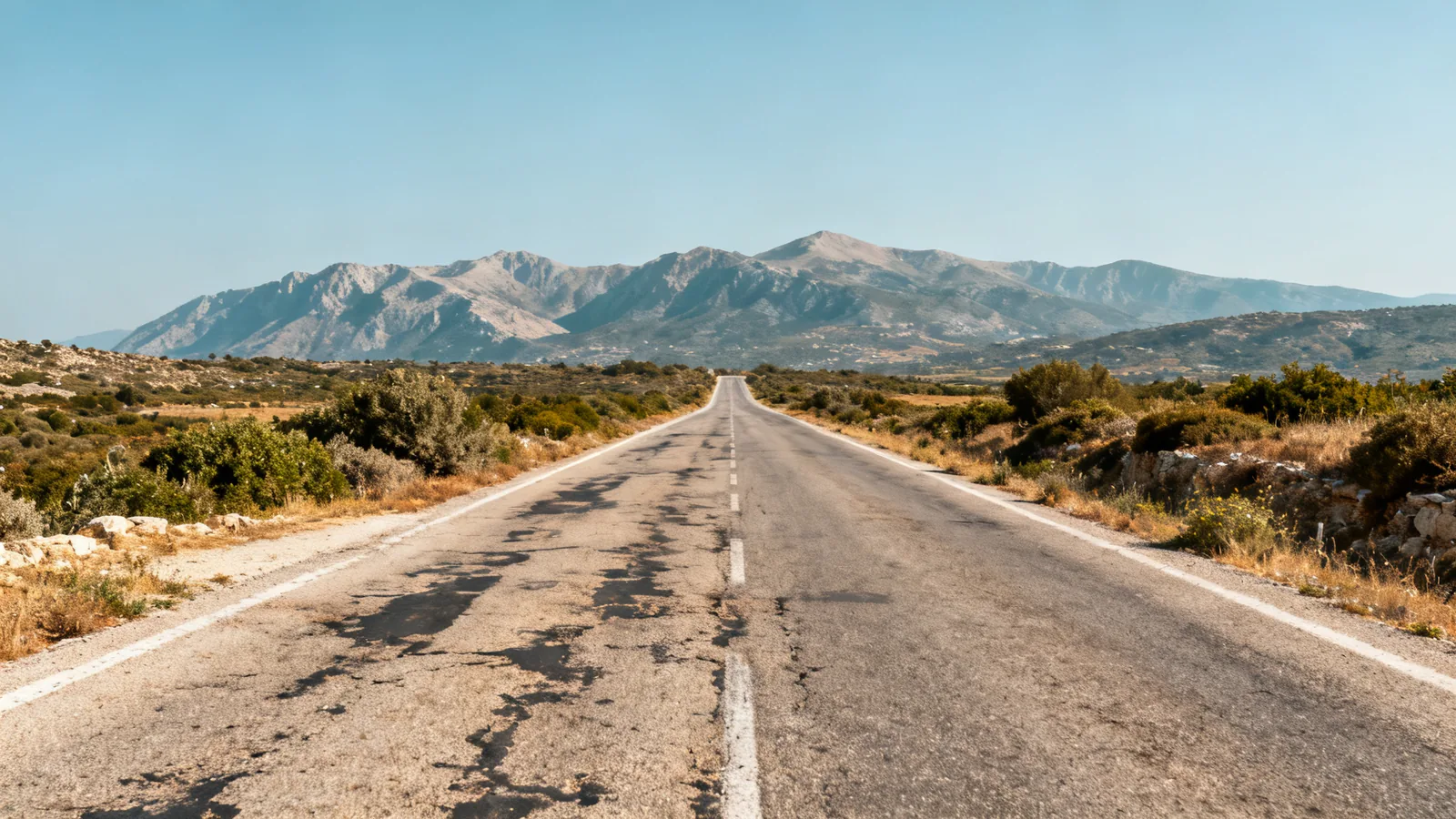 A long road across northern Crete with distant mountains